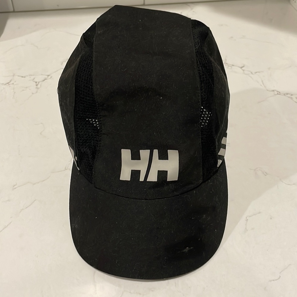 Black Helly Hansen cap with a small pocket and mesh on the sides.